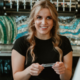 female bartender smiling and holding ID